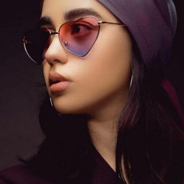 عکس از خانمی که عینک آفتابی فانتزی با فریم قلبی و لنز دو رنگ مدل 324-681 به چشم زده است