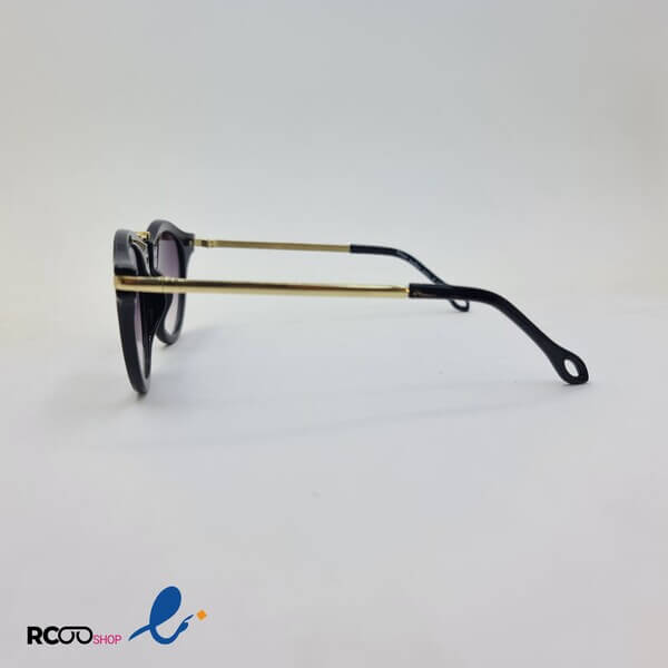 عکس از عینک آفتابی گرد مشکی رنگ با دسته و پل بینی فلزی و طلایی رنگ مدل 1101 برند کارن واکر karen walker