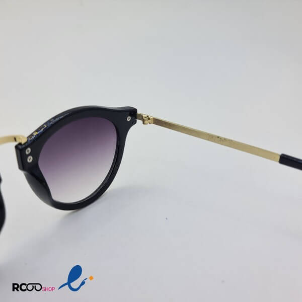 عکس از عینک آفتابی گرد مشکی رنگ با دسته و پل بینی فلزی و طلایی رنگ مدل 1101 برند کارن واکر karen walker