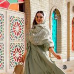 عکس از خانم زیبایی که عینک آفتابی گرد با عدسی آینه ای و فریم طلایی کد 324-388 را به چشم زده است