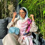 عکس از خانم زیبایی که عینک آفتابی گرد با عدسی آینه ای و فریم طلایی کد 324-388 را به چشم زده است