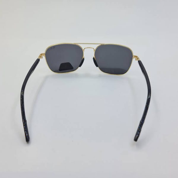 عکس از عینک آفتابی پلاریزه برند ریبن ray-ban با فریم طلایی و دسته مشکی مدل d21533