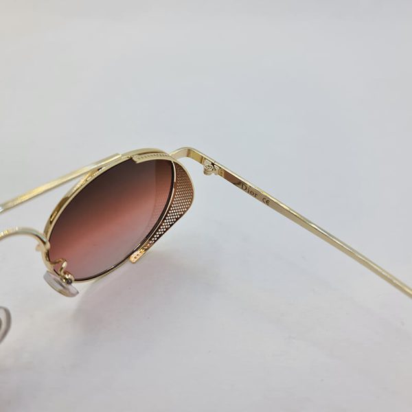 عکس از عینک آفتابی dior با عدسی قرمز تیره و فریم گرد و طلایی رنگ مدل 5012