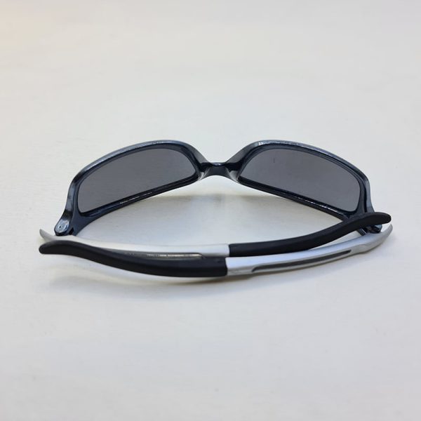 عکس از عینک ورزشی با فریم نوک مدادی و دسته نقره ای و لنز دودی مدل t117