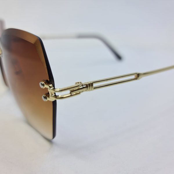 عکس از عینک آفتابی فریم لس پروانه ای با لنز قهوه ای و دسته طلایی مدل b300