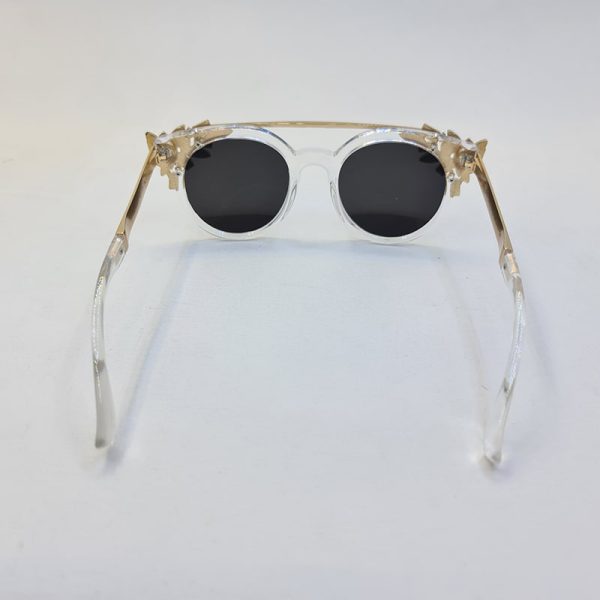عکس از عینک آفتابی گرد نگین دار با فریم بی رنگ و دسته طلایی برند swarovski مدل 6697