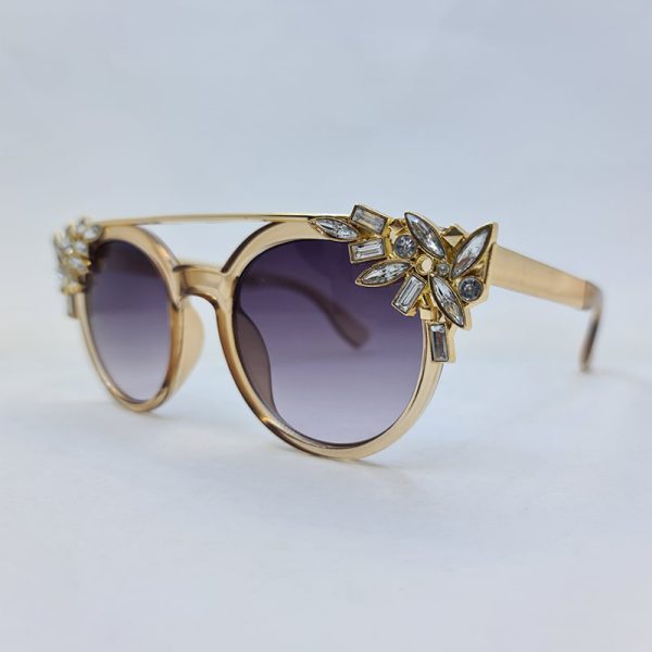 عکس از عینک آفتابی گرد نگین دار با رنگ عسلی و دسته طلایی فلزی برند swarovski مدل 6697