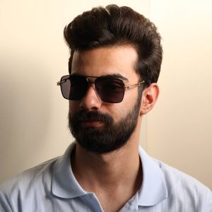 عکس از عینک آفتابی لاکچری میباخ با فریم شکل مربعی، رنگ مشکی، دسته طلایی و لنز دودی تیره مدل 2A401 بر روی صورت محمدحسین ابراهیم زاده