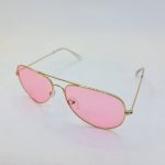 عکس از عینک دید در شب با لنز صورتی رنگ و فریم طلایی خلبانی Ray-Ban مدل 3026