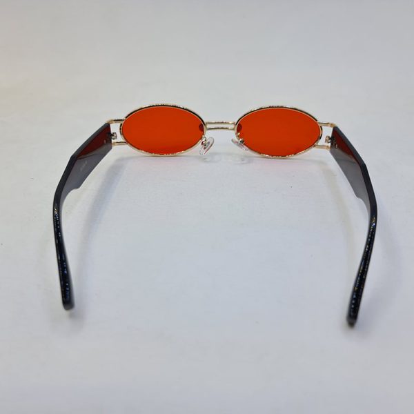 عکس از عینک شب جنتل مانستر با فریم طلایی، بیضی شکل و دسته مشکی و لنز قرمز مدل b2069