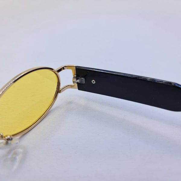عکس از عینک شب جنتل مانستر با فریم طلایی، بیضی شکل و دسته مشکی و لنز زرد مدل b2069