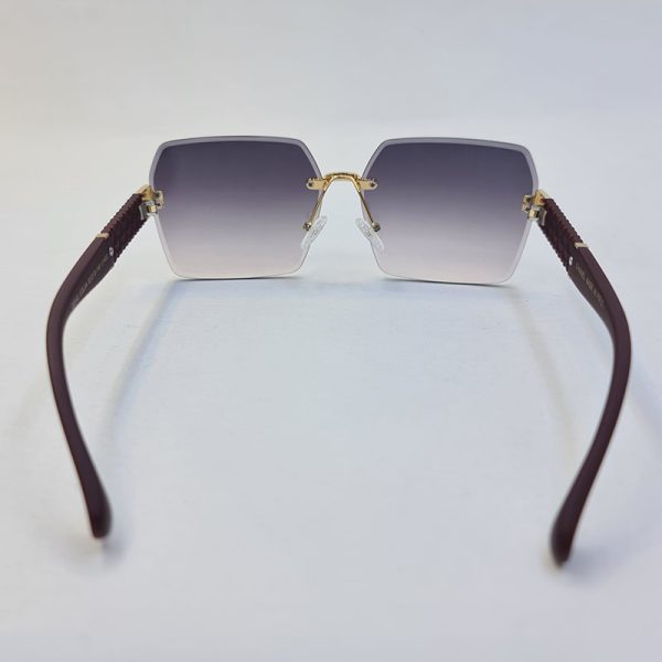 عکس از عینک آفتابی زنانه بدون فریم با دسته زرشکی و لنز هایلایت شنل مدل d2340
