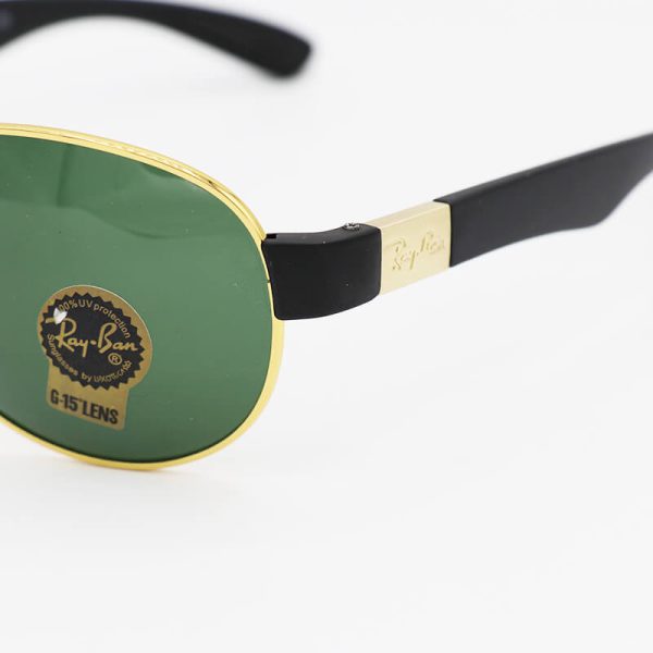 عکس از عینک آفتابی ری‌بن ضدانعکاس با فریم خلبانی، طلایی و لنز سبز و سنگ مدل rb3509