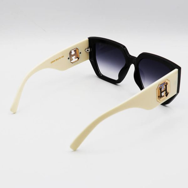 عکس از عینک آفتابی hermes با فریم مشکی، دسته شیری و پهن و لنز هایلایت مدل 23008