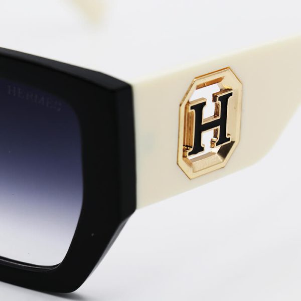 عکس از عینک آفتابی hermes با فریم مشکی، دسته شیری و پهن و لنز هایلایت مدل 23008