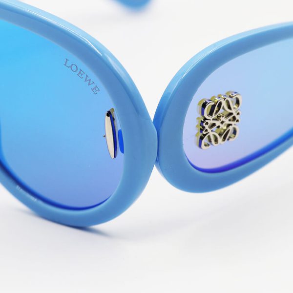 عکس از عینک آفتابی فانتزی با فریم آبی رنگ، لنز جیوه ای و دسته پهن loewe مدل 0239