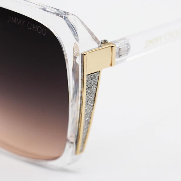 عکس از عینک آفتابی زنانه با فریم بی‌رنگ و شفاف، شاین‌دار و لنز قهوه‌ای جیمی چو مدل 7204