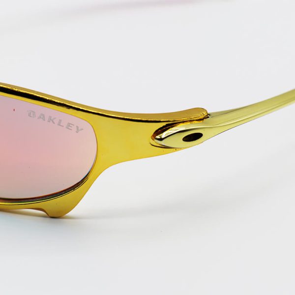 عکس از عینک آفتابی oakley با فریم طلایی رنگ، لنز آینه ای و قرمز رنگ مدل w2239