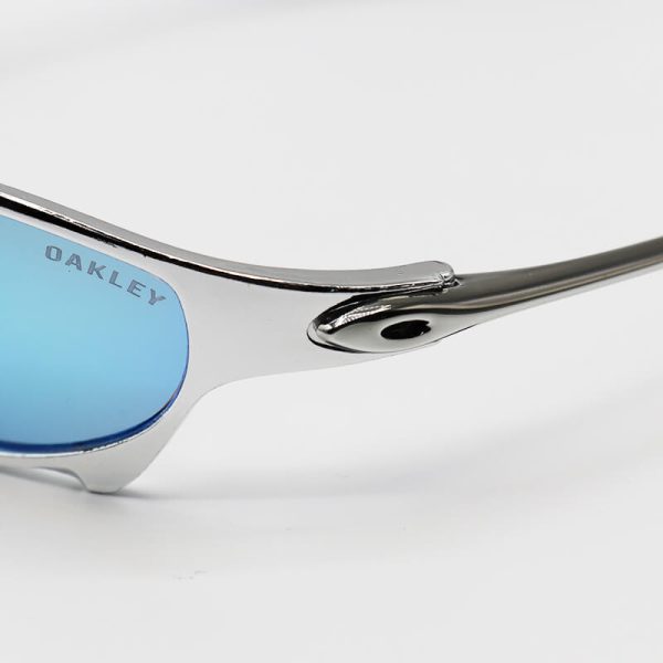 عکس از عینک ورزشی oakley با فریم نقره ای رنگ، لنز آینه ای و آبی رنگ مدل w2239