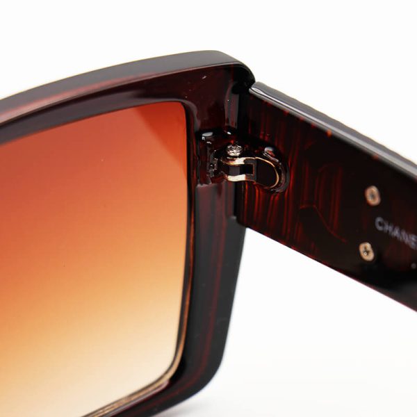 عکس از عینک آفتابی زنانه با فریم قهوه ای رنگ، مربعی شکل و لنز هایلایت شنل مدل 6929