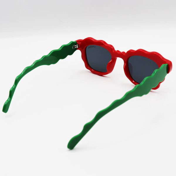 عکس از عینک آفتابی فانتزی زنانه با فریم قرمز رنگ، دسته سبز، ویفرر و لنز دودی شنل مدل fa455