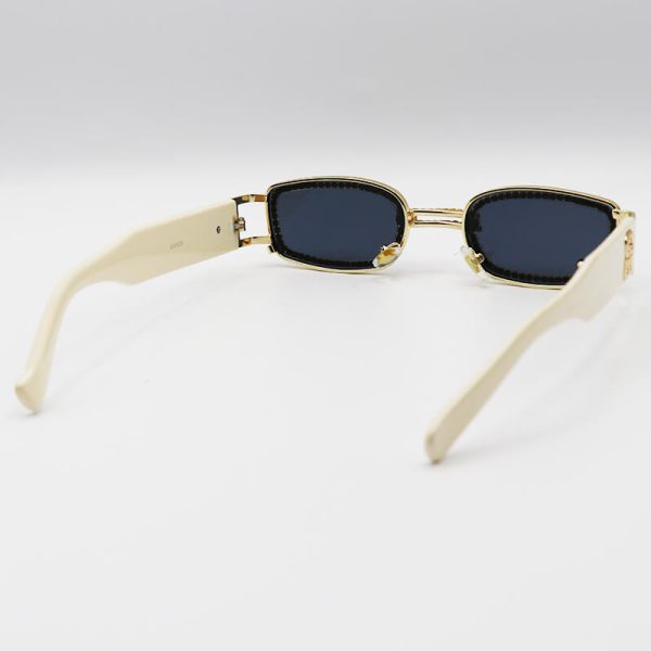 عکس از عینک آفتابی پیرسینگ دار، با فریم نگین دار، طلایی رنگ و دسته کرمی جنتل مانستر مدل gw003