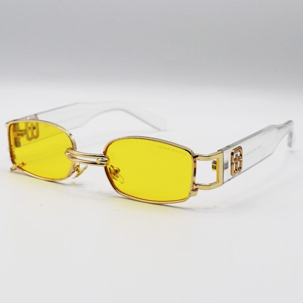 عکس از عینک شب پیرسینگ دار، با فریم مستطیلی شکل، طلایی رنگ و دسته شفاف جنتل مانستر مدل 8032