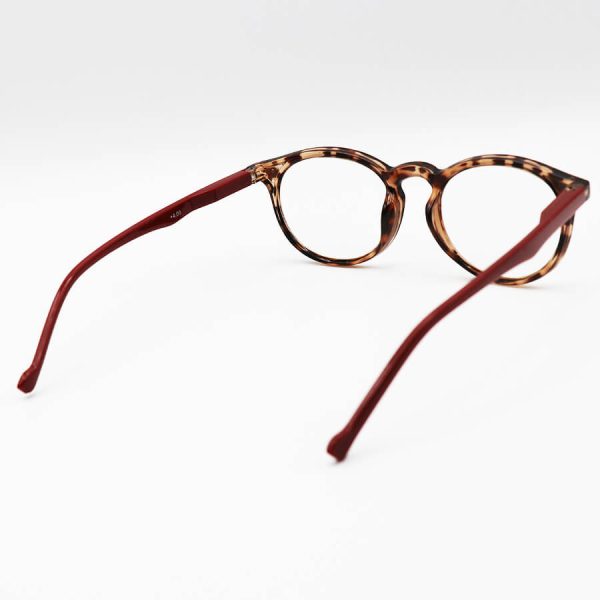 عکس از عینک مطالعه نزدیک بین با لنز بلوکات، فریم قهوه ای، شکل گرد و دسته قرمز مدل arz05