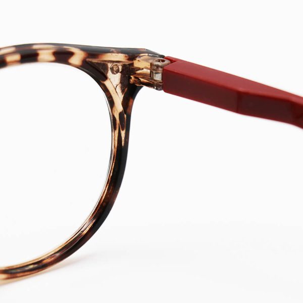 عکس از عینک مطالعه نزدیک بین با لنز بلوکات، فریم قهوه ای، شکل گرد و دسته قرمز مدل arz05