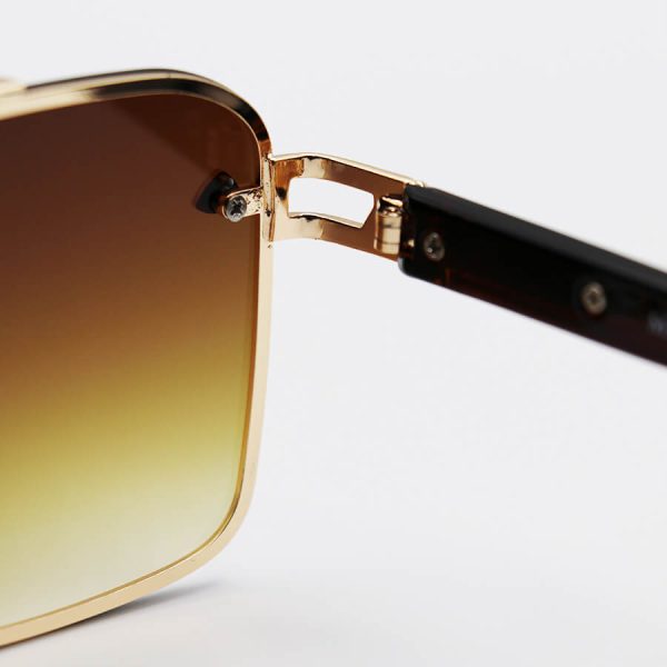 عکس از عینک آفتابی می‌باخ با فریم طلایی، شکل چندضلعی، دسته مشکی و لنز قهوه ای هایلایت مدل 22384