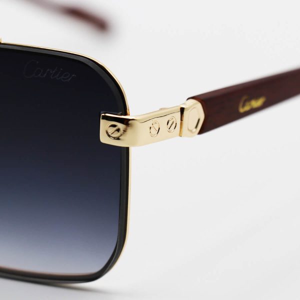 عکس از عینک آفتابی طلایی cartier با فریم مستطیلی شکل، لنز دودی هایلایت و دسته چوب مدل 22046