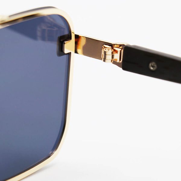عکس از عینک آفتابی cartier با فریم طلایی رنگ، مستطیلی شکل، لنز دودی تیره و دسته چوبی مدل 22046