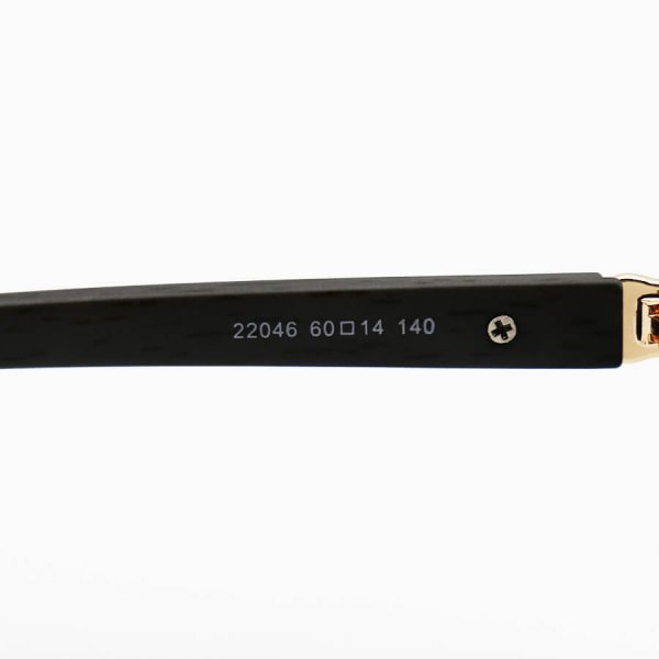 عکس از عینک آفتابی cartier با فریم طلایی رنگ، مستطیلی شکل، لنز دودی تیره و دسته چوبی مدل 22046