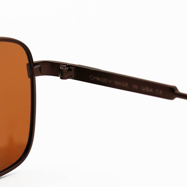 عکس از عینک آفتابی اوکلی با فریم چندضلعی، رنگ مسی، عدسی قهوه ای تیره و پلاریزه مدل 008922