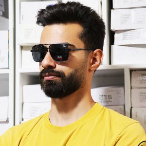 عکس از عینک آفتابی اوکلی با فریم چندضلعی و عدسی پلاریزه مدل 008922 بر روی صورت محمدحسین ابراهیم زاده