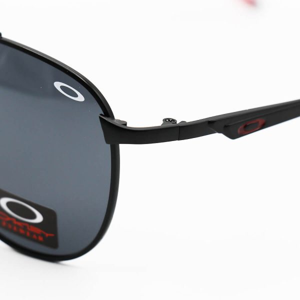 عکس از عینک آفتابی oakley با فریم خلبانی، مشکی و قرمز رنگ، لنز پلاریزه و دودی تیره مدل 008920