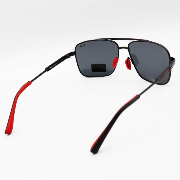 عکس از عینک آفتابی oakley با فریم هندسی، مشکی و قرمز رنگ، لنز دودی تیره و پلاریزه مدل 008922