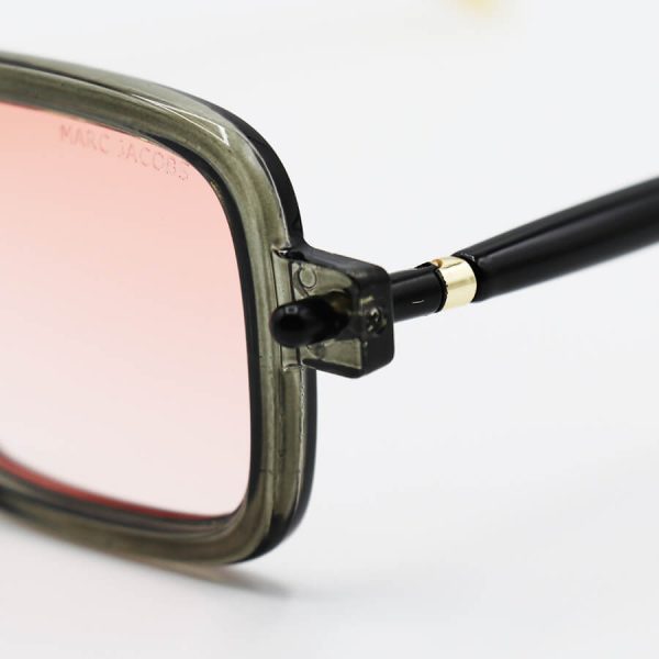 عکس از عینک آفتابی مستطیلی با فریم طوسی رنگ، دسته مدادی و لنز صورتی هایلایت مارک جیکوبز مدل 8708