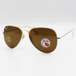 عکس از عینک آفتابی خلبانی Ray-Ban با فریم طلایی، لنز سنگ، قهوه ای رنگ، آنتی رفلکس و پلاریزه مدل 3026-S62