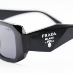 عکس از عینک آفتابی PRADA با فریم مستطیلی شکل، مشکی براق و لنز دودی تیره مدل SL312