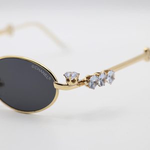 عکس از عینک آفتابی زنانه با فریم بیضی، طلایی رنگ، نگین دار و عدسی دودی تیره Chanel مدل 30678