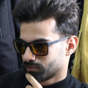 عکس از عینک دید در شب اوگا مورل با فریم مشکی مات، مستطیلی شکل، دسته فنری و لنز زرد رنگ مدل 78051 بر روی صورت محمدحسین ابراهیم زاده