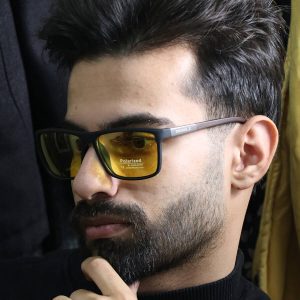عکس از عینک شب دیزل با فریم مشکی مات، مستطیلی، دسته چوبی، رنگ قهوه‌ای و لنز پلاریزه و زرد رنگ مدل P5304 بر روی صورت محمدحسین ابراهیم زاده