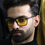 عکس از عینک شب دیزل با فریم مشکی مات، مستطیلی، دسته چوبی، رنگ قهوه‌ای و لنز پلاریزه و زرد رنگ مدل P5304 بر روی صورت محمدحسین ابراهیم زاده