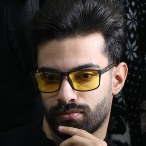 عکس از عینک شب Diesel با فریم مشکی مات، مستطیلی، دسته چوبی، رنگ قهوه‌ای و لنز پلاریزه و زرد رنگ مدل P5320 بر روی صورت محمدحسین ابراهیم زاده