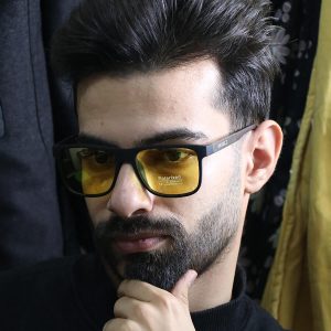 عکس از عینک شب دیزل با فریم مربعی، مشکی مات، دسته چوبی، رنگ قهوه‌ای و لنز پلاریزه و زرد رنگ مدل P5310 بر روی صورت محمدحسین ابراهیم زاده