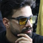 عکس از عینک شب DIESEL با فریم مربعی، مشکی مات، دسته چوبی، رنگ قهوه‌ای و لنز پلاریزه و زرد رنگ مدل P5314 بر روی صورت محمدحسین ابراهیم زاده