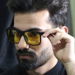 عکس از عینک شب DIESEL با فریم مربعی، مشکی مات، دسته چوبی، رنگ قهوه‌ای و لنز پلاریزه و زرد رنگ مدل P5316 بر روی صورت محمدحسین ابراهیم زاده