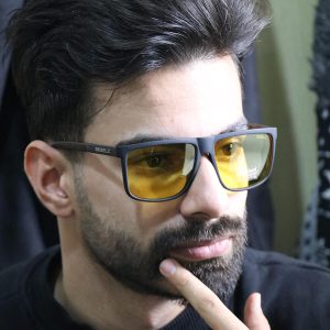 عکس از عینک شب دیزل با فریم مربعی، مشکی مات، دسته چوبی، رنگ قهوه‌ای و لنز پلاریزه و زرد رنگ مدل P5318 بر روی صورت محمدحسین ابراهیم زاده