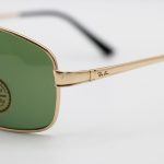 عکس از عینک آفتابی Ray-Ban با فریم طلایی مات، شکل خلبانی و لنز سبز تیره و از جنس شیشه مدل RB3317
